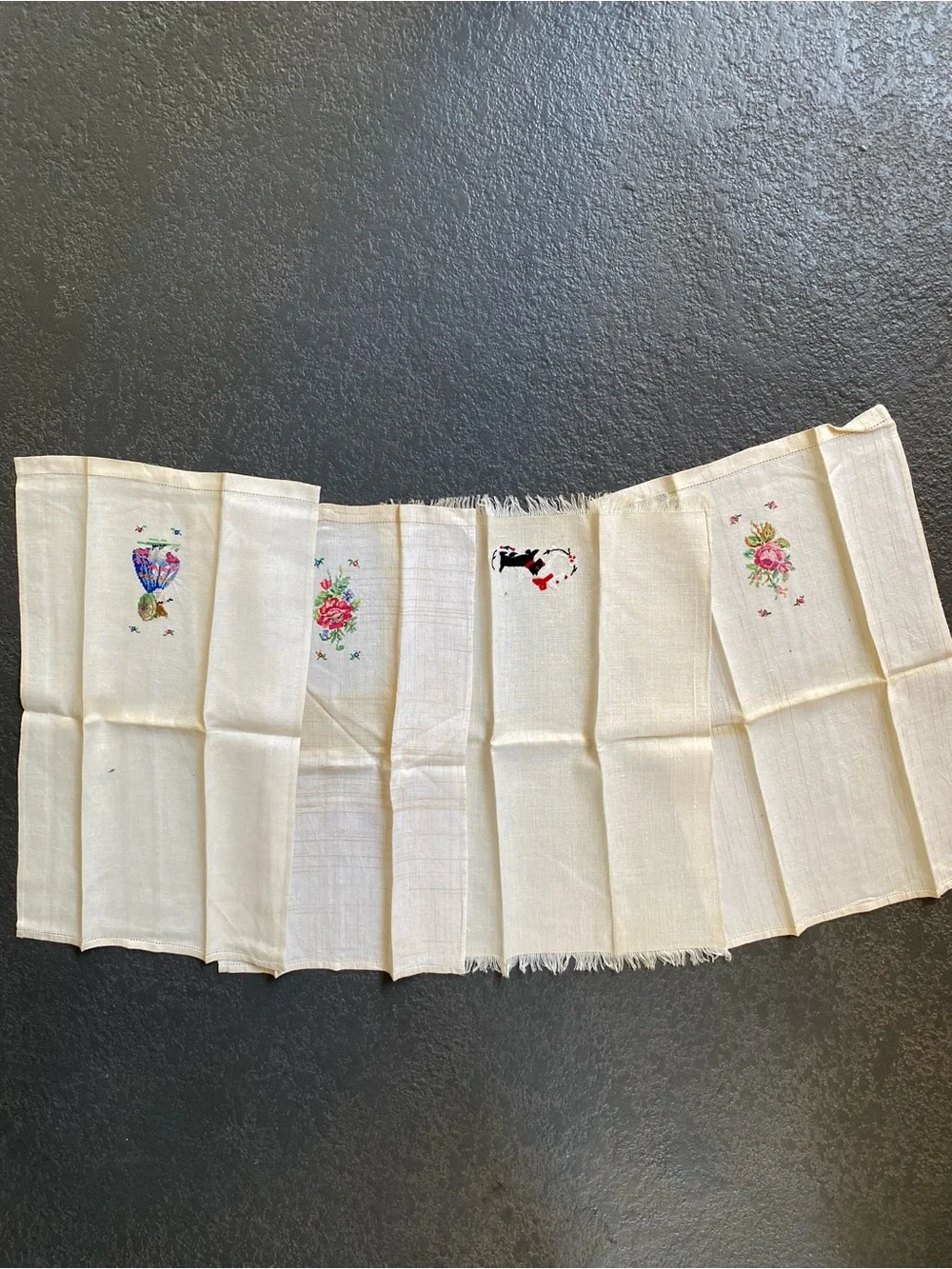 The image shows a set of four vintage hand-embroidered and cross-stitched